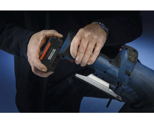 Osoba vkládá akumulátor ze systému Bosch Professional 18 voltů do přímočaré pily.