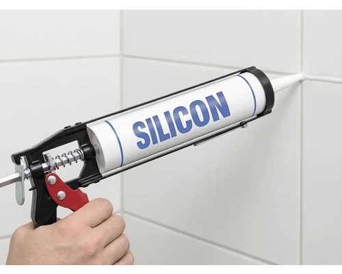Nanášení silikonu pomocí vytlačovací pistole na spáru obkladů.