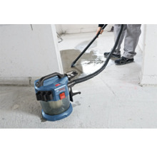 Akumulátorový vysavač pro mokré a suché sání Bosch Professional při vysávání vody z betonové podlahy.