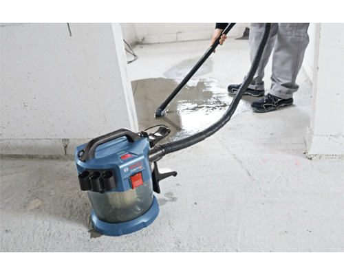 Akumulátorový vysavač pro mokré a suché sání Bosch Professional při vysávání vody z betonové podlahy.