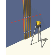 Křížový čárový laser na stativu promítá červené laserové čáry pro vyrovnání svislých trubek na stěně.