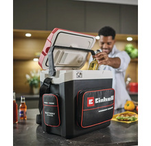 Akumulátorový chladicí box Einhell Power X-Change v kuchyni, muž vyndává láhev s pitím z otevřeného boxu s kapsami na příslušenství.