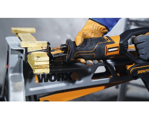 Akumulátorová pila ocaska řeže dřevo na pracovním stole, ovládá ji osoba v rukavicích, viditelné logo Worx.