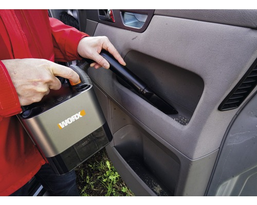 Osoba vysává interiér auta akumulátorovým vysavačem značky Worx