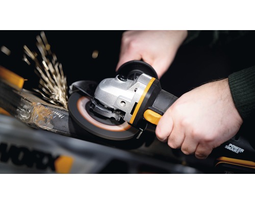 Osoba používá úhlovou brusku k broušení kovu, přičemž vznikají jiskry.