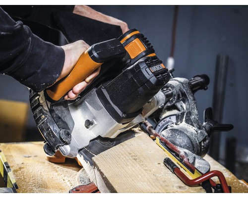 Kapovací a pokosová pila řeže dřevěný obrobek. Logo Worx.