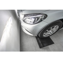 Stříbrné auto na parkovací podložce v garáži