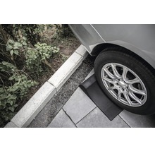 Nájezdový klín pod pneumatikou auta na dlažebních kostkách