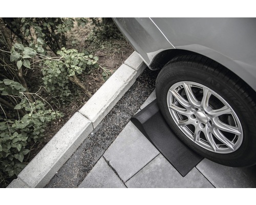 Nájezdový klín pod pneumatikou auta na dlažebních kostkách