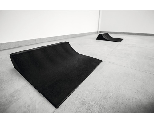 Dvě černé skateboardové rampy na dlážděné podlaze