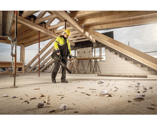 Dělník používá foukač listí Metabo na staveništi k odstranění nečistot a pilin.