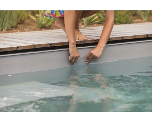 Osoba opravuje bazénovou fólii pomocí sady na opravu fólií