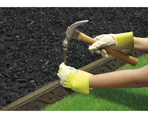 Zahradní krajina s lemem trávníku, kladivem a osobou