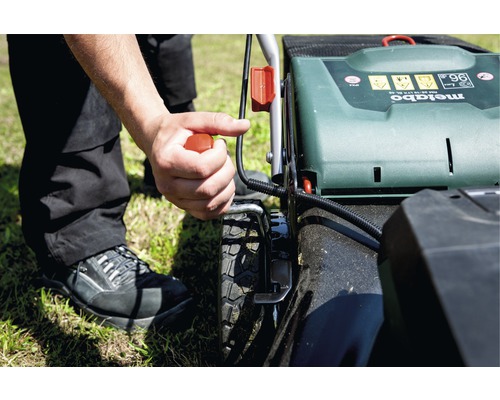 Osoba startuje sekačku na trávu značky Metabo