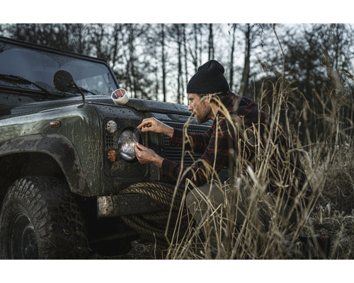 Muž nanáší ochrannou fólii proti odletujícím kamínkům na světlomet