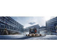 Stavební scéna se stavebním rádiem na paletě před hrubou stavbou