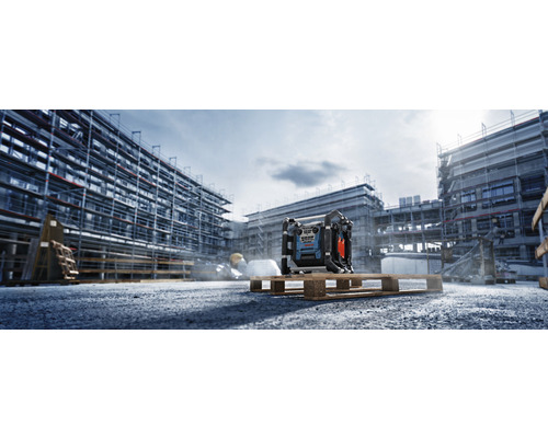 Stavební scéna se stavebním rádiem na paletě před hrubou stavbou