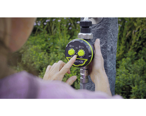 Osoba nastavuje zavlažovací počítač značky SEKA na vodovodním kohoutku.