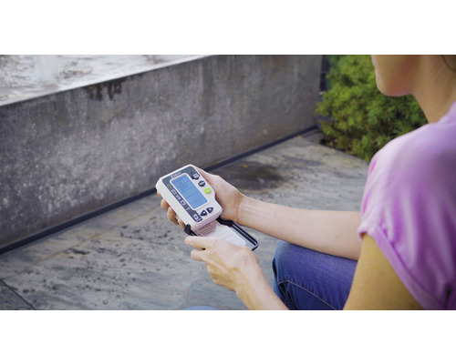 Osoba drží v ruce měřič vlhkosti půdy Gardena