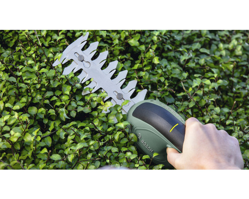 Akumulátorové nůžky na živý plot v provozu na živém plotu. Logo Bosch.