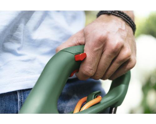 Ruka drží vyžínač s bezpečnostním spínačem