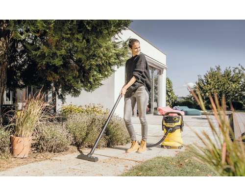 Žena uklízí terasu víceúčelovým vysavačem.