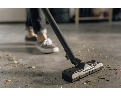 Vysavač v provozu na podlaze se špínou