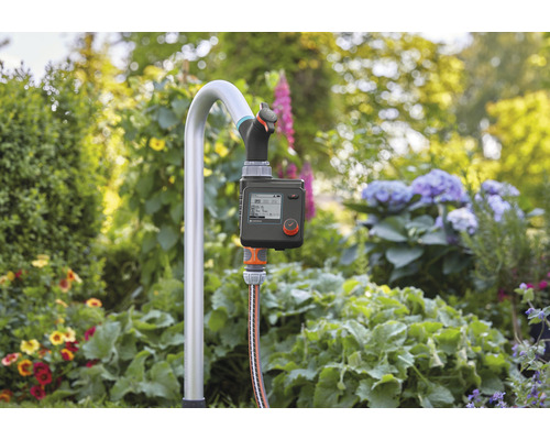 Řídicí jednotka zavlažování s namontovaným vodovodním kohoutkem na zahradě