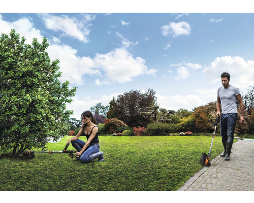 Zahradní scéna se sekačkami na trávu pracujícími na zahradě.