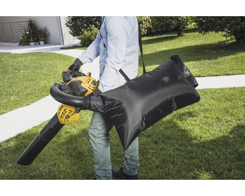 Osoba s fukarem na listí a sběrným vakem na zahradě