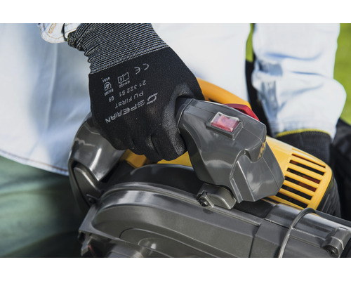 Osoba obsluhuje vysavač listí s ochrannými rukavicemi