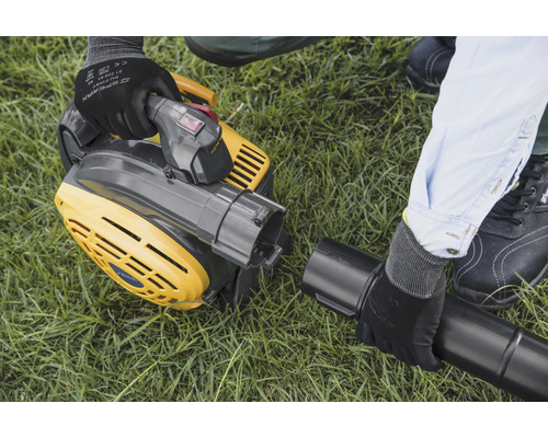 Žlutý vysavač listí se montuje na trávník.