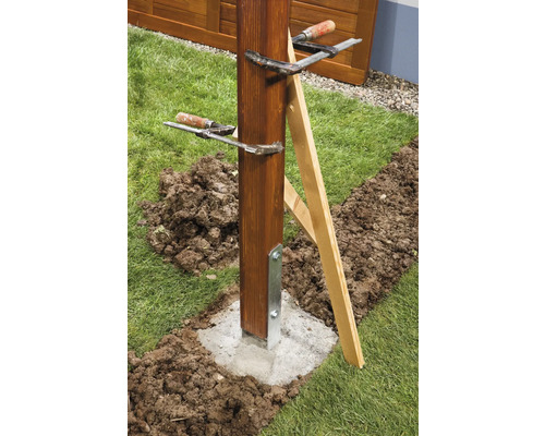 Dřevěný sloupek upevněný v betonovém základu pomocí šroubových svorek