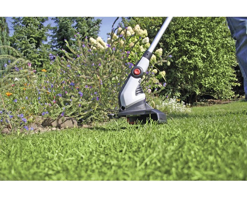 Zastřihovač trávy v provozu na zahradě