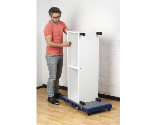 Muž pohybuje bílou polici na vozíku.