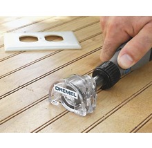 Frézovací nástavec Dremel používaný na dřevěném povrchu s výřezem pro zásuvku