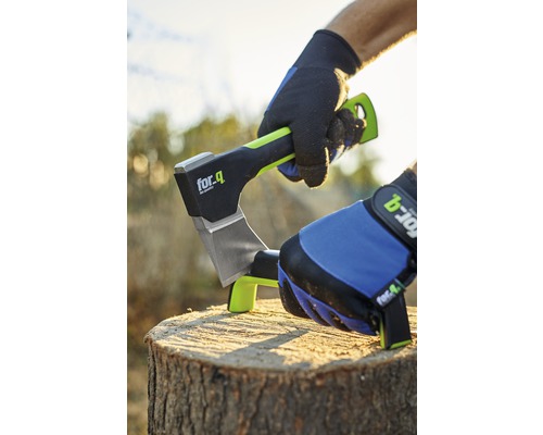 Sekera for_q je zaseknutá v pařezu stromu. Osoba v rukavicích sekeru pevně drží.