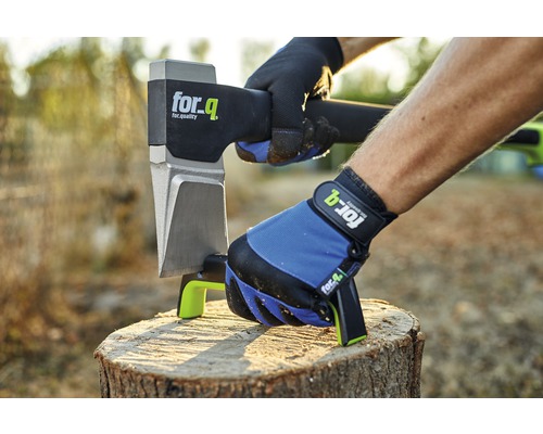 Osoba se štípací sekerou for_q a pracovními rukavicemi při štípání dřeva