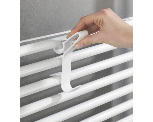 Ruka zavěšuje háček na radiátor na radiátor