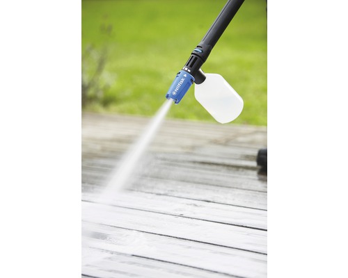 Tlakový čistič s lahví čisticího prostředku používaný na dřevěné terase