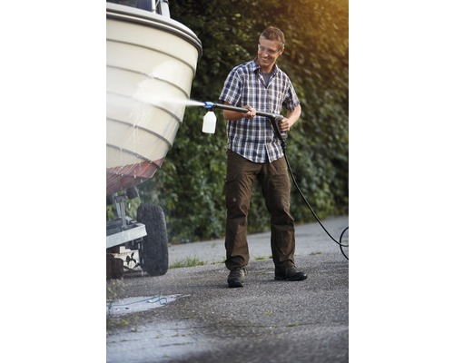 Muž čistí loď vysokotlakým čističem.