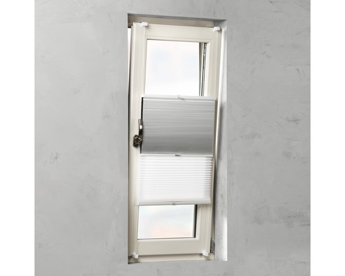 Okno s šedou a bílou plisovanou žaluzií