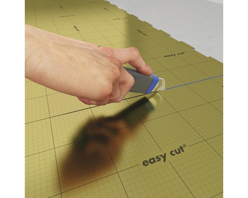 Ruka řeže izolační desky řezákem.