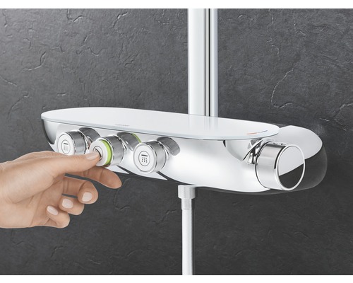 Snímek ruky ovládající sprchovou armaturu