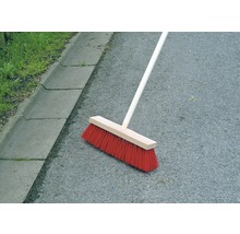 Koště s dřevěnou násadou na asfaltu
