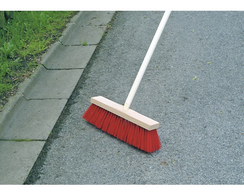 Koště s dřevěnou násadou na asfaltu