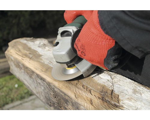 Osoba brousí kus dřeva pomocí úhlové brusky