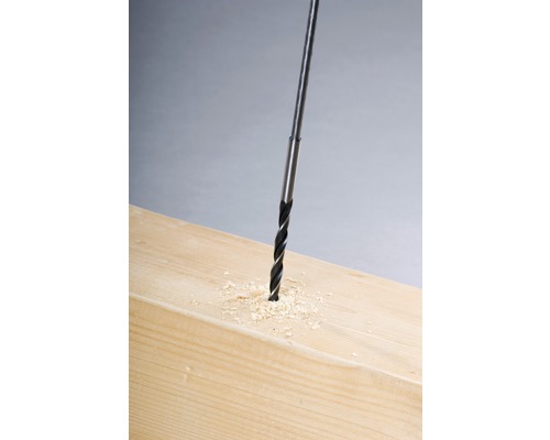 Vrták do dřeva vrtá otvor do dřevěné desky.