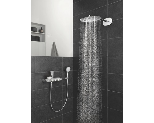 Koupelna s hlavovou a ruční sprchou na tmavé stěně s dlaždicemi