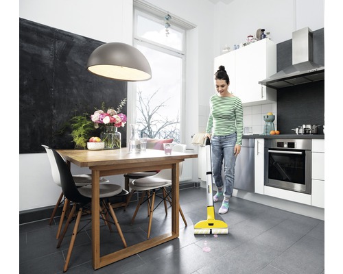 Žena uklízí kuchyň elektrickým mopem